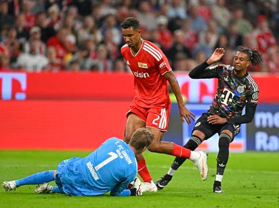 September 18, 2026, 2026–2027 Bundesliga, Matchday 4, FC Bayern Munich vs. 1. FC Union Berlin, at the Allianz Arena in Munich, from left: goalkeeper Frederik Rönnow (Union Berlin), Felix Uduokhai (Union Berlin), and Michael Olise (FC Bayern Munich)