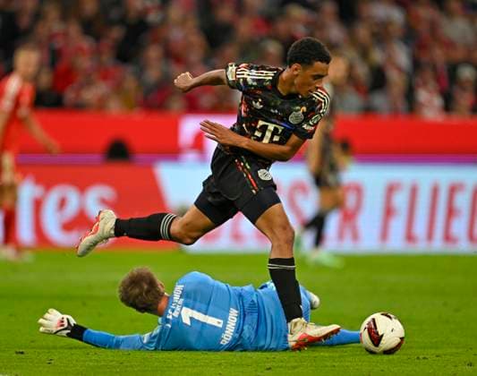 September 18, 2026, 2026–2027 Bundesliga, Matchday 4, FC Bayern Munich vs. 1. FC Union Berlin, at the Allianz Arena in Munich, Jamal Musiala (Bayern Munich) vs. goalkeeper Frederik Rönnow (Union Berlin)
