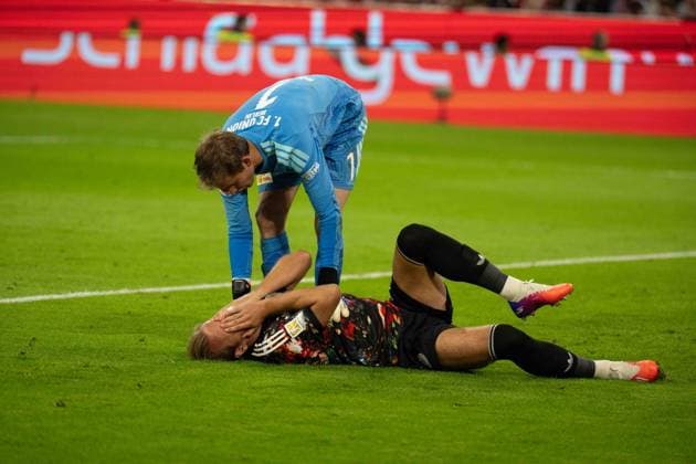 September 18, 2026: Soccer – FC Bayern Munich vs. Union Berlin, Matchday 4 of the Bundesliga at the Allianz Arena in Munich. Harry Kane (FC Bayern Munich) lies injured on the ground after a tackle by Frederik Rönnow (Union Berlin), 1 comes to his aid IMPORTANT NOTICE: In accordance with DFL and DFB regulations, it is prohibited to use or allow the use of photographs taken in the stadium and or during the game in the form of sequential images and or video-like photo series. Copyright: xJamesxZabelx