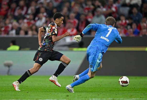 Tackle, Action: Jamal Musiala (FC Bayern Munich, FCB) 10 vs. goalkeeper Frederik Rönnow (1. FC Union Berlin, FCU) 01 FC Bayern Munich (FCB) vs. 1. FC Union Berlin (FCU) September 18, 2026 DFL regulations prohibit any use of photographsHS AS IMAGE SEQUENCES AND OR QUASI-VIDEO FC Bayern Munich FCB vs. 1. FC Union Berlin FCU