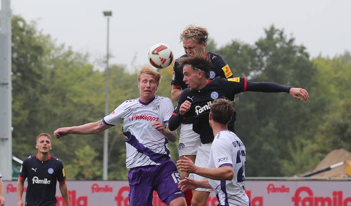 Bjarke Jacobsen of VfL Osnabrück in a header duel with two Kiel players; Soccer, Men s, 2026–2027 Season, 2. Bundesliga, Holstein Stadium, Holstein Kiel vs. VfL Osnabrück, 1–1. DFL regulations prohibit any use of photographs as image sequences and or quasi-video.
