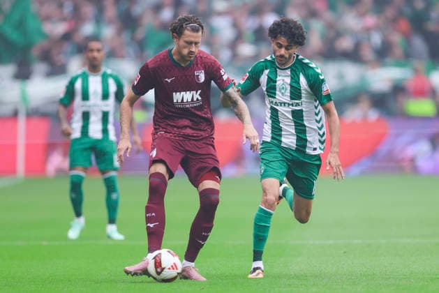 Calvin Brackelmann of FC Augsburg and Eren Dinkci of Werder Bremen battle for the ball during the Bundesliga match between SV Werder Bremen and FC Augsburg at Weserstadion on September 19, 2026, in Bremen, Germany Photo by Marco Steinbrenner, DeFodi Images Calvin Brackelmann of FC Augsburg and Eren Dinkci of Werder Bremen battle for the ball during the Bundesliga match between SV Werder Bremen and FC Augsburg at Weserstadion on September 19, 2026 in Bremen, Germany. Photo by Marco Steinbrenner, DeFodi Images. DFB and DFL regulations prohibit any use of photographs as image sequences and or quasi-video. Photo by Marco Steinbrenner, DeFodi Images.
