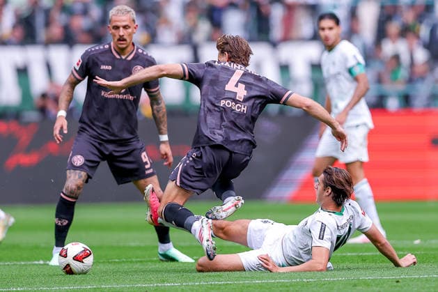 September 19, 2026, Soccer, Borussia Mönchengladbach vs. FSV Mainz 05, Bundesliga 1, Matchday 4, Ista Borussia Park, 2026–27 season: Stefan Posch (1 FSV Mainz 05) No. 04 in a tackle against Florian Neuhaus (Borussia Mönchengladbach No. 10). DFB regulations prohibit any use of photographs as image sequences and or quasi-video. North Rhine-Westphalia, Germany