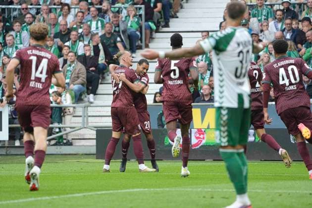 Photo: Goal celebration in Augsburg after Alexis Claude Maurice scored to make it 0–2; Marius WOLF, seen flying in from the top right, offers his congratulations. Augsburg Soccer, Bundesliga 1, Matchday 30 on Sat, Apr 18, 2026: Werder Bremen vs. Hamburger SV