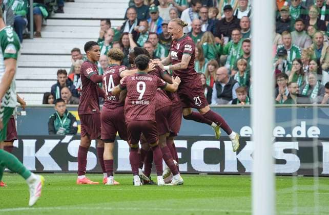 Photo: Goal celebration in Augsburg after Alexis Claude Maurice scored to make it 0–2; Marius WOLF, seen flying in from the top right, offers his congratulations. Augsburg Soccer, Bundesliga 1, Matchday 30 on Sat, Apr 18, 2026: Werder Bremen vs. Hamburger SV