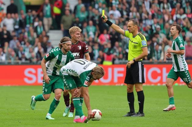 September 26, 19, GER, Soccer, 1st Bundesliga Men, Matchday 4, 2026–2027 Season, SV Werder Bremen vs. FC Augsburg: Referee Bastian Dankert shows Hennes Behrens (FC Augsburg, No. 16) a yellow card at the Weserstadion in Bremen, Germany Copyright: xnordphotoxGmbHx xTauchnitzx