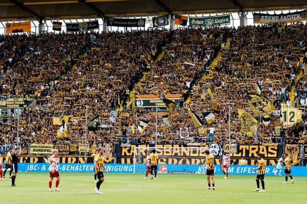 Germany Soccer 3rd Division 2026–2027, Matchday 7: Alemannia Aachen vs. Fortuna Düsseldorf at Tivoli Aachen—scarves displayed at the top of the Werner Fuchs Stand, You ll Never Walk Alone, fan support, sold out, Ultras Copyright: xThiemoxRudolphx