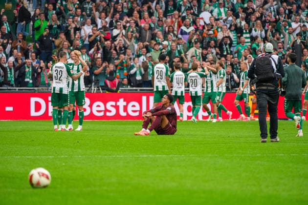 Noahkai Banks of FC Augsburg, 40, sits on the ground, disappointed and frustrated, after the final whistle, while Werder Bremen celebrates in the background; German soccer, Bundesliga, 2026–27 season, Matchday 4, September 19, 2026, Werder Bremen vs. FC Augsburg, Weserstadion, Bremen Copyright: xLeonxFrickx
