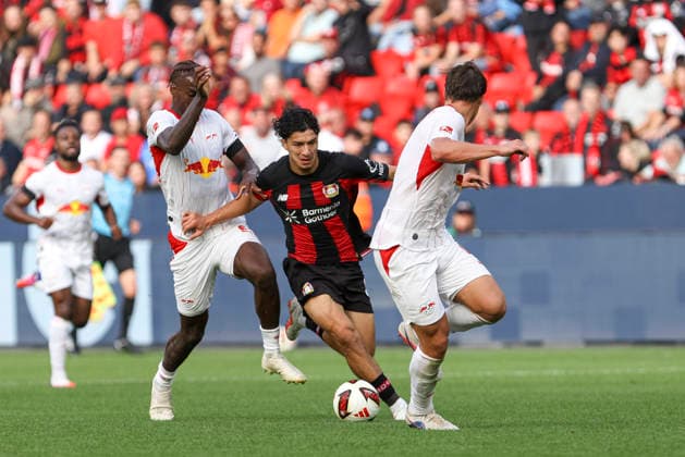 Ezechiel Banzuzi (RB Leipzig), Ibrahim Maza (Bayer 04 Leverkusen), and Willi Orban (RB Leipzig) in a tackle during the Bundesliga 1 match between Bayer 04 Leverkusen and RB Leipzig, BayArena on September 20, 2026, in Leverkusen, Germany. Photo by Oliver Kaelke, DeFodi Images. Ezechiel Banzuzi (RB Leipzig), Ibrahim Maza of Bayer 04 Leverkusen, and Willi Orban of RB Leipzig battle for the ball during the Bundesliga match between Bayer 04 Leverkusen and RB Leipzig at BayArena on September 20, 2026 in Leverkusen, Germany. Photo by Oliver Kaelke, DeFodi Images. DFB and DFL regulations prohibit any use of photographs as image sequences and or quasi-video. Photo by Oliver Kaelke, DeFodi Images.