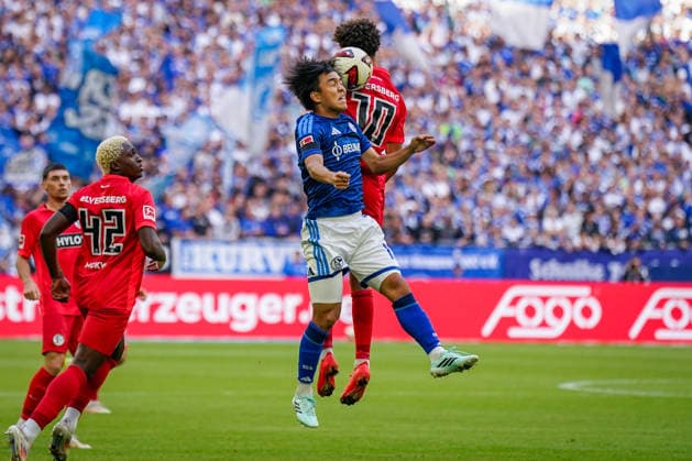 German Bundesliga 2026–2027, Matchday 4: FC Schalke 04 vs. SV Elversberg at Veltins Arena in Gelsenkirchen. Satoshi Tanaka (FC Schalke 04, No. 13) and Noah Darvich (SV Elversberg, No. 10) battle for the ball in an aerial duel. Copyright: xJOERANxSTEINSIEKx