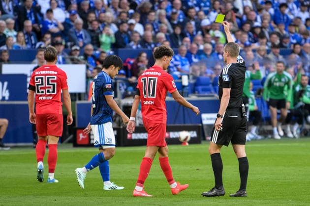 Soccer, Bundesliga 1, 20260920, FC Schalke 04 vs. SC 07 Elversberg. Pictured, from left: Noah DARVICH (Elversberg, age 10) and referee Robin BRAUN showing a yellow card. Gelsenkirchen, Veltins Arena, North Rhine-Westphalia, Germany Copyright: Passion2Press MarkusxFischerx