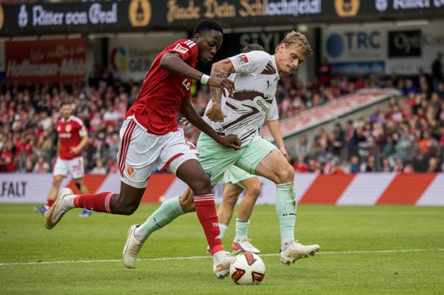 Cottbus, Germany, September 20, 2026, 2nd Bundesliga 2026–2027, Matchday 6: FC Energie Cottbus vs. FC St. Pauli. Pictured, from left, in a tackle: King Manu (Energie Cottbus) and Eric Smith (St. Pauli). DFL and DFB regulations prohibit any use of photographs as image sequences and or quasi-video. LEAG Energie Brandenburg Stadium Copyright: xFotostandx xWeilandx
