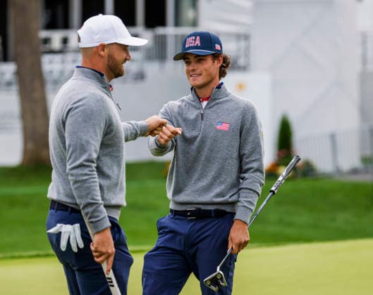 Jackson Koivun of the US (R) fist bumps with Wyndham Clark of the US (L) during practice for the Presidents Cup golf tournament at Medinah Country Club in Medinah, Illinois on Monday, September 21, 2026. Competition between the USA and the International team begins on Thursday, September 24 with Four-Ball play.  MED20260922809 TANNENxMAURY