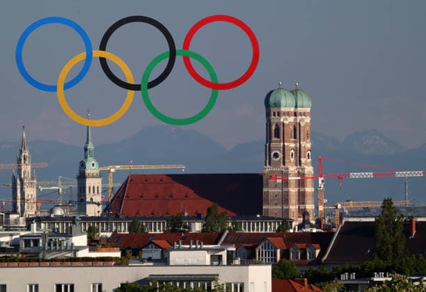 ATTENTION: PHOTOMONTAGE, FOR EDITORIAL USE ONLY. Pictured here is the Munich skyline, featuring the Frauenkirche and other landmarks; a cityscape where a vote is being held on whether to award the Summer Olympics to Munich once again, Munich’s Olympic bid, Olympics, state capital, shown here with the Olympic rings in the background, vote, vote