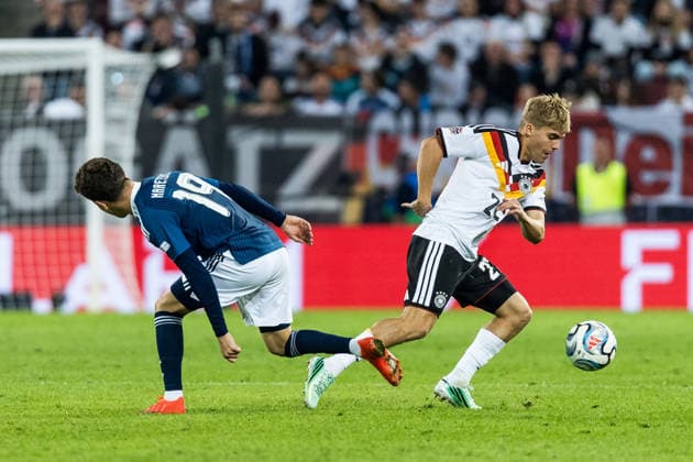 AUGSBURG, GERMANY - SEPTEMBER 27: Hennes Behrens (Germany, 22) controls the ball against Konstantinos Karetsas (Greece, 19) during the UEFA Nations League match between Germany vs. Greece at WWK Arena on matchday 2 of the UEFA Nations League on September 27, 2026 in Augsburg, Germany. Bavaria Germany Copyright: xSteffiexWunderlx
