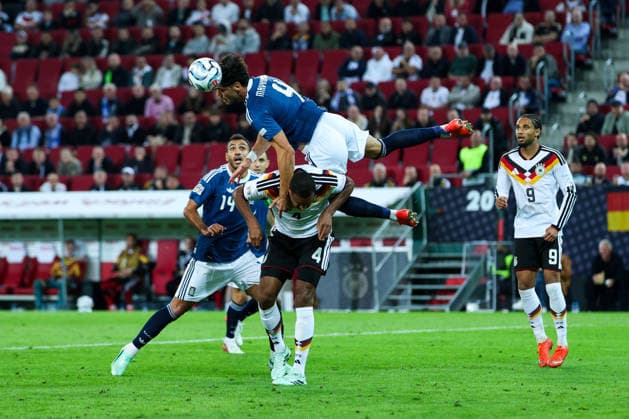 September 27, 2026, GER, Soccer, Men s, UEFA Nations League, League A, 2026–2027 Season, Matchday 2, Germany vs. Greece: Tasos Douvikas (Greece) 9, top; Jonathan Tah (Germany) 4, bottom. DFB and DFL regulations prohibit any use of photographs as image sequences and or quasi-video. Augsburg WWK Arena, Bavaria, Germany Copyright: xNordphoto Schneiderx
