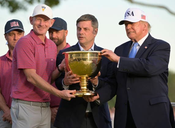 President Donald Trump (R) and PGA, Golf Herren Tour CEO Brian Rolapp (C) present the Presidents Cup trophy to US Team Captain Brandt Snedeker after the United States team defeated the International Team 15.5 to 12.5 at Medinah Country Club in Chicago, Illinois, on Sunday, September 27, 2026.  CHI20260927838 MARKxBLACK
