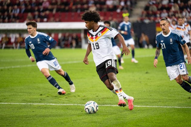 GER, Bavaria, Augsburg, Soccer, Germany vs. Greece, at the WWK Arena, Augsburg, UEFA Nations League, Matchday 2, Group Stage, September 27, 2026, from left: Christos Tzolis (Greece), 10; Karim Adeyemi (Germany), 19; Kostas Tsimikas (Greece), 21; forward on the attack. DFL and DFB regulations prohibit any use of photographs as image sequences and or quasi-video, Copyright: HMB-Media MichaelxNibel
