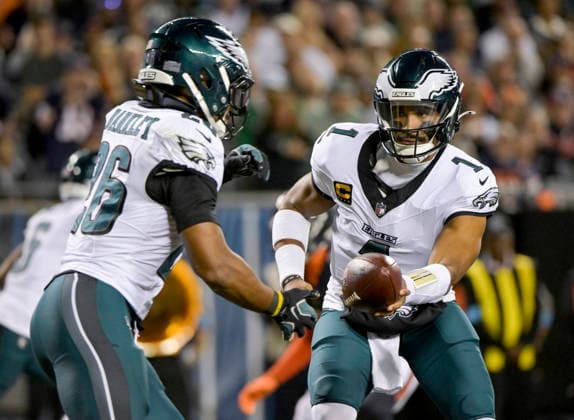 Philadelphia Eagles quarterback Jalen Hurts (1) hands off the ball to running back Saquon Barkley (26) during a game against the Chicago Bears at Soldier Field in Chicago on Monday, September 28, 2026. Bears defeated the Eagles 27-7.  CHI20260928128 MARKxBLACK
