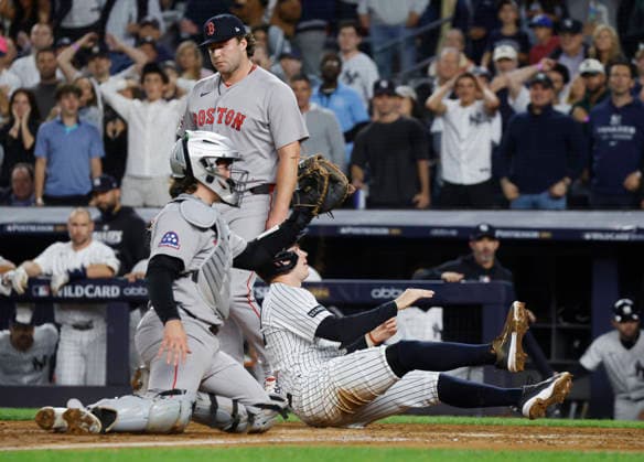 New York Yankees Ben Rice (22) is tagged out at home by Boston Red Sox catcher Adley Rutschman (31) on a throw from Red Sox left fielder Nate Eaton in the fifth inning of an MLB, Baseball Herren, USA American League Wild Card game at Yankee Stadium in New York City, on Wednesday, September 30, 2026.  NYP20260930714 JOHNxANGELILLO