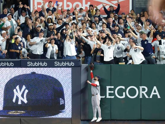 Fans reach for a home run ball from New York Yankees left fielder Cody Bellinger as Boston Red Sox center fielder Ceddanne Rafaela leaps in the sixth inning of an MLB, Baseball Herren, USA American League Wild Card game at Yankee Stadium in New York City, on Wednesday, September 30, 2026.  NYP20260930723 JOHNxANGELILLO