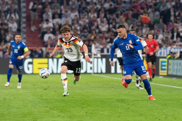 Philipp Treu (13, Germany) and Filip Kostic (11, Serbia) in action during the UEFA Nations League match between Germany and Serbia on October 1, 2026, in Munich at the Allianz Arena, Bavaria, Germany