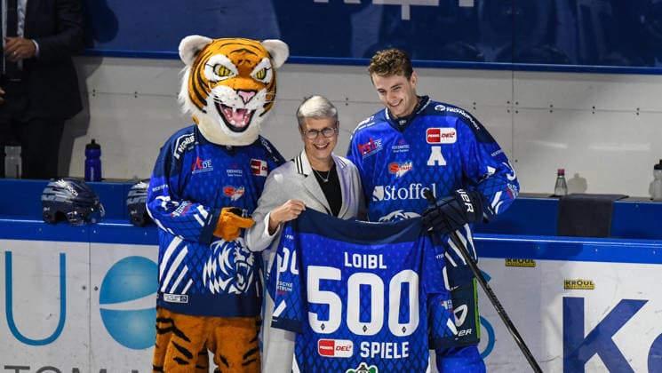 Stefan Loibl of the Straubing Tigers with Gaby Sennebogen and Tigo at the ceremony honoring his 500th game, Men s Ice Hockey, German Ice Hockey League, Penny DEL, Matchday 5, 2026–2027 season on October 2, 2026, at the Eisstadion am Pulverturm, Straubing Tigers (blue) vs. Pinguins Bremerhaven (white)