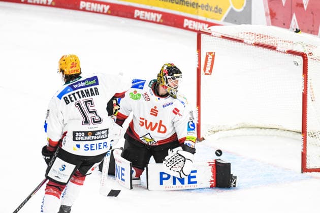 Marcel Brandt of the Straubing Tigers, not pictured, beats Kristers Gudlevskis of the Bremerhaven Penguins; Men s Ice Hockey, German Ice Hockey League, Penny DEL, Matchday 5, 2026–2027 season on October 2, 2026, at the Eisstadion am Pulverturm, Straubing Tigers (blue) vs. Pinguins Bremerhaven (white)