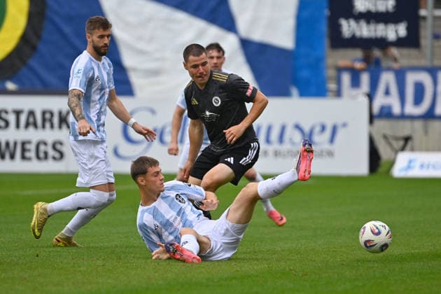 Mirko PUSCHER in action, tackling Emre ERDOGAN, 1860 Munich vs. Eric UHLMANN, 1860 Munich, Bavarian Regional League, 2026–2027 season,Matchday 26–27, December 12: TSV 1860 Munich vs. SpVgg Ansbach on October 3, 2026, at Grünwalder Stadium in Munich