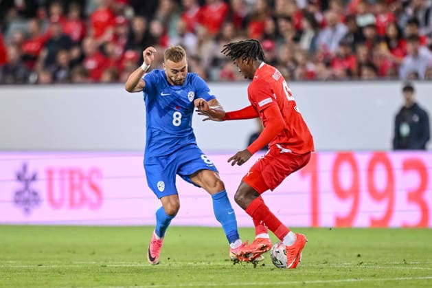 Sandi Lovric of Slovenia and Johan Manzambi of Switzerland battle for the ball during the UEFA Nations League 2026–27 group stage match between Switzerland and Slovenia at Luzern Arena on October 3, 2026, in Lucerne, Switzerland. Photo by Harry Langer, DeFodi Images