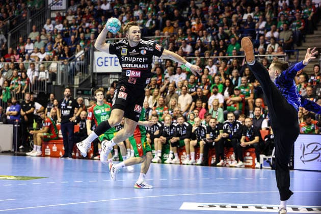 Christopher Bissel of HC Erlangen, 21, against goalkeeper Dominik Kuzmanovic of SC Magdeburg, 1. Handball Bundesliga, 2026–2027 season. SC Magdeburg vs. HC Erlangen at the GETEC Arena in Magdeburg. Action, handball, Germany, October 4, 2026