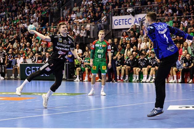Yannik Bialowa of HC Erlangen (7) against goalkeeper Dominik Kuzmanovic of SC Magdeburg (1). Handball Bundesliga 2026–2027 season: SC Magdeburg vs. HC Erlangen at the GETEC Arena in Magdeburg. Action, handball,Germany, October 4, 2026