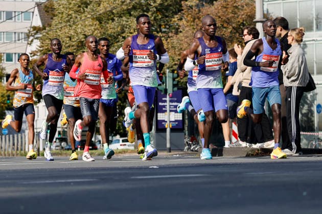 The leading group of men, led by the eventual winner, Kenyan Bernard Kiprop Koech (in the red jersey), third from the left at the 28th Generali Cologne Marathon in 2026, runs through downtown Cologne. Numerous spectators cheer on the runners with homemade signs. Thematic image, symbolic image. Cologne, October 4, 2026. North Rhine-Westphalia, Germany Copyright: xChristophxHardtx