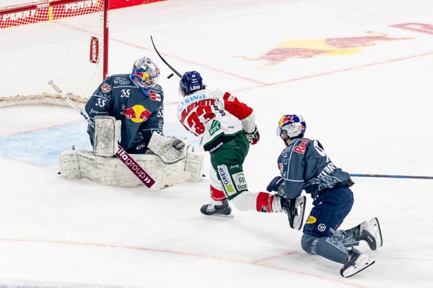 Tim Wohlgemuth of the Augsburger Panther, 33, is stopped by Mathias Niederberger, goaltender for EHC Red Bull Munich, 35, and Moritz Warnecke of EHC Red Bull Munich, 09 GER, EHC Red Bull Munich vs. Augsburger Panther, DEL, 2026–2027 season, Matchday 6, October 4, 2026. Photo: HMB Media, Franz Feiner Copyright: HMBxMedia FranzxFeiner