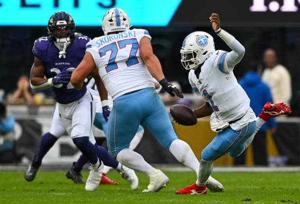 Tennessee Titans quarterback Cam Ward (1) scrambles out of the pocket against the Baltimore Ravens defense during the first quarter at M&T Bank Stadium in Baltimore, Maryland, on Sunday, October 4, 2026.  BAL20261004108 DAVIDxTULIS