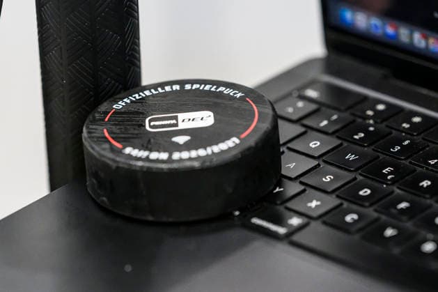 In the photo, from left: a puck—the Penny DEL game puck—lands on the keyboard of a MacBook; GER, BW, VS, Penny DEL, Ice Hockey League, Matchday 6, Schwenninger Wild Wings vs. Straubing Tigers at the Helios Arena in Villingen-Schwenningen, October 4, 2026, Copyright: HMBxMedia UwexKoch