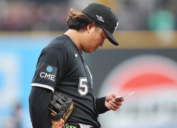 Chicago White Sox first baseman Munetaka Murakami (5) reads a slip of paper during the fourth inning against the Cleveland Guardians in an MLB, Baseball Herren, USA American League Division Series playoff game at Progressive Field in Cleveland, Ohio, on Monday, October 5, 2026.  CLE20261005716 AARONxJOSEFCZYK