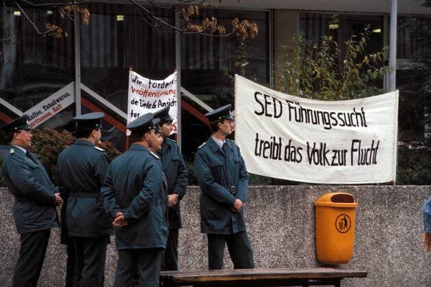 Berliner Polizisten neben Transparenten von der Protestkundgebung in Berlin-Mitte