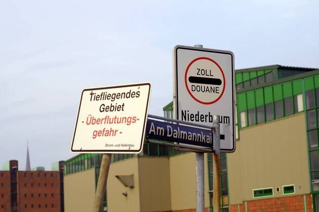 Kleiner Schilderwald im Hamburger Freihafen - Zoll , Straßenname und Warnschild vor Überflutungen