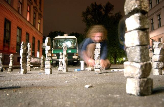 1.Mai-Krawalle in Berlin-Kreuzberg - Jugendlicher stapelt Pflastersteine auf der Straße sitzend - Ruhe vor dem Sturm