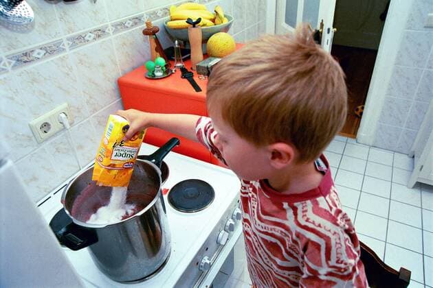 Junge schüttet Gelierzucker in den Topf - Marmelade einkochen