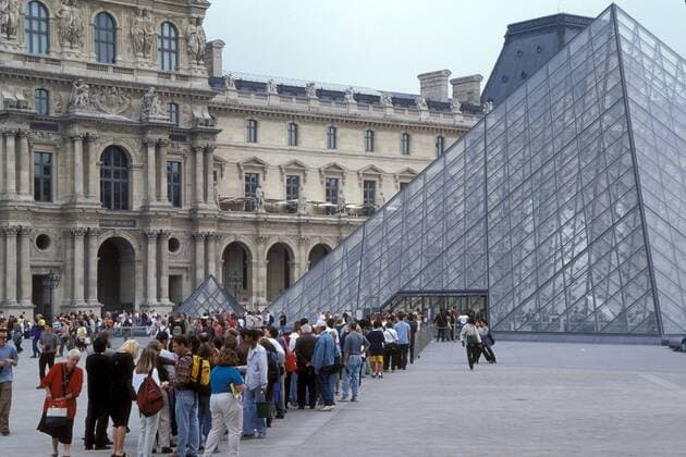 Besucherschlange vor der Glaspyramide des Louvre in Paris