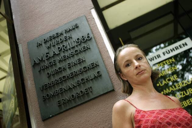 Karola Flemming (Überlebende des Bombenanschlags auf die Berliner Discothek - La Belle - vom 5. April 1986) vor der Gedenktafel für die Ermordeten