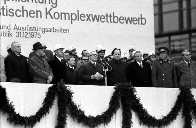 Erich Honecker (Mitte, GDR Staatsratsvorsitzender der DDR und Generalsekretär des Zentralkomitees der SED) hält eine Rede auf der von Genossen besetzten Tribüne während des Richtfestes am Palast der Republik in Ost Berlin