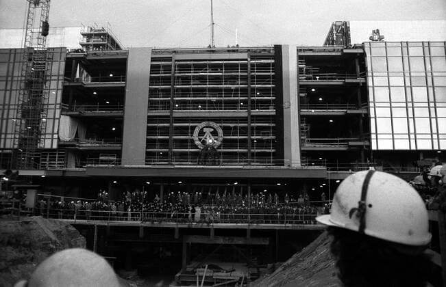 Bauarbeiter vor Baugrube und Baustelle während des Richtfestes am Palast der Republik in Ost Berlin