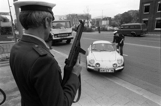 Polizeikontrolle eines Autos während der Fahndung nach den Mördern Hans Schleyers in Bonn - Polizist hält eine Maschinenpistole im Anschlag