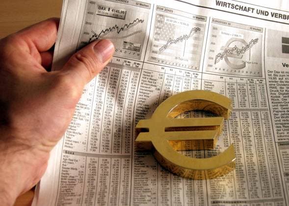 Goldenes Eurozeichen liegt auf dem Wirtschaftsteil einer Tageszeitung