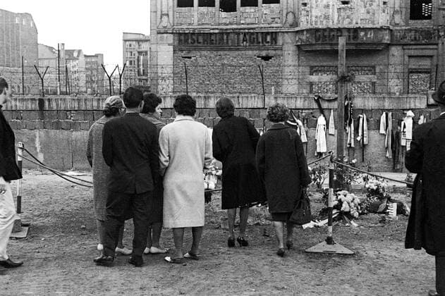Trauernde vor der Gedenkstätte für Peter Fechter an der Berliner Mauer - Fechter wurde bei einem Fluchtversuch von Schüssen der DDR-Grenzposten getroffen und verblutete auf dem Grenzstreifen