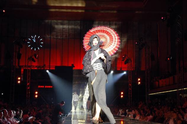 Model mit Kopftuch, japanisch anmutendem Kimono-Kleid und Papierregenschirm während der Abschlussshow DEFILE der letzten UDK-Modeklasse von Vivienne Westwood in Berlin