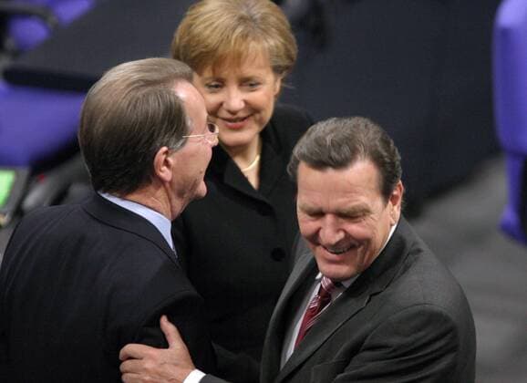 An Dr. Angela Merkel (Mitte, GER CDU Bundeskanzlerin) im Gespräch mit Franz Müntefering (li., GER SPD Minister für Arbeit und Soziales) huscht Alt-Kanzler Gerhard Schröder (re., GER SPD) vorbei - Parlamentssitzung zur Vereidigung der ersten Deutschen Bundeskanzlerin im Deutschen Bundestag in Berlin